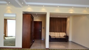 Ein Hotelzimmer mit einem großen Spiegel, einem Kleiderschrank, einer Couch und Teppichboden.