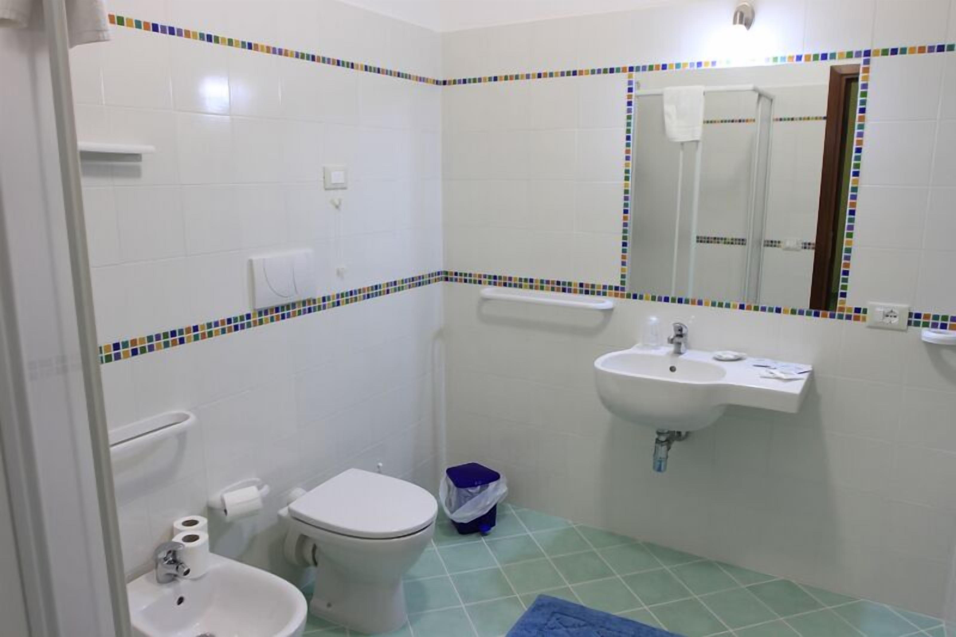Une salle de bain avec des toilettes, un lavabo et un miroir.