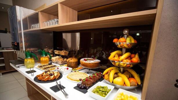 Un bufé con diversos alimentos, como frutas, pasteles y postres.