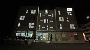Un hotel con fachada moderna, varias ventanas y un letrero que indica que es un hotel 'dm'.