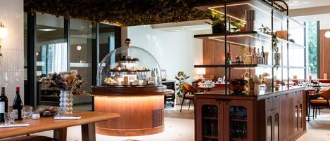 A restaurant with a wooden counter, a glass display case, and a seating area with tables and chairs.