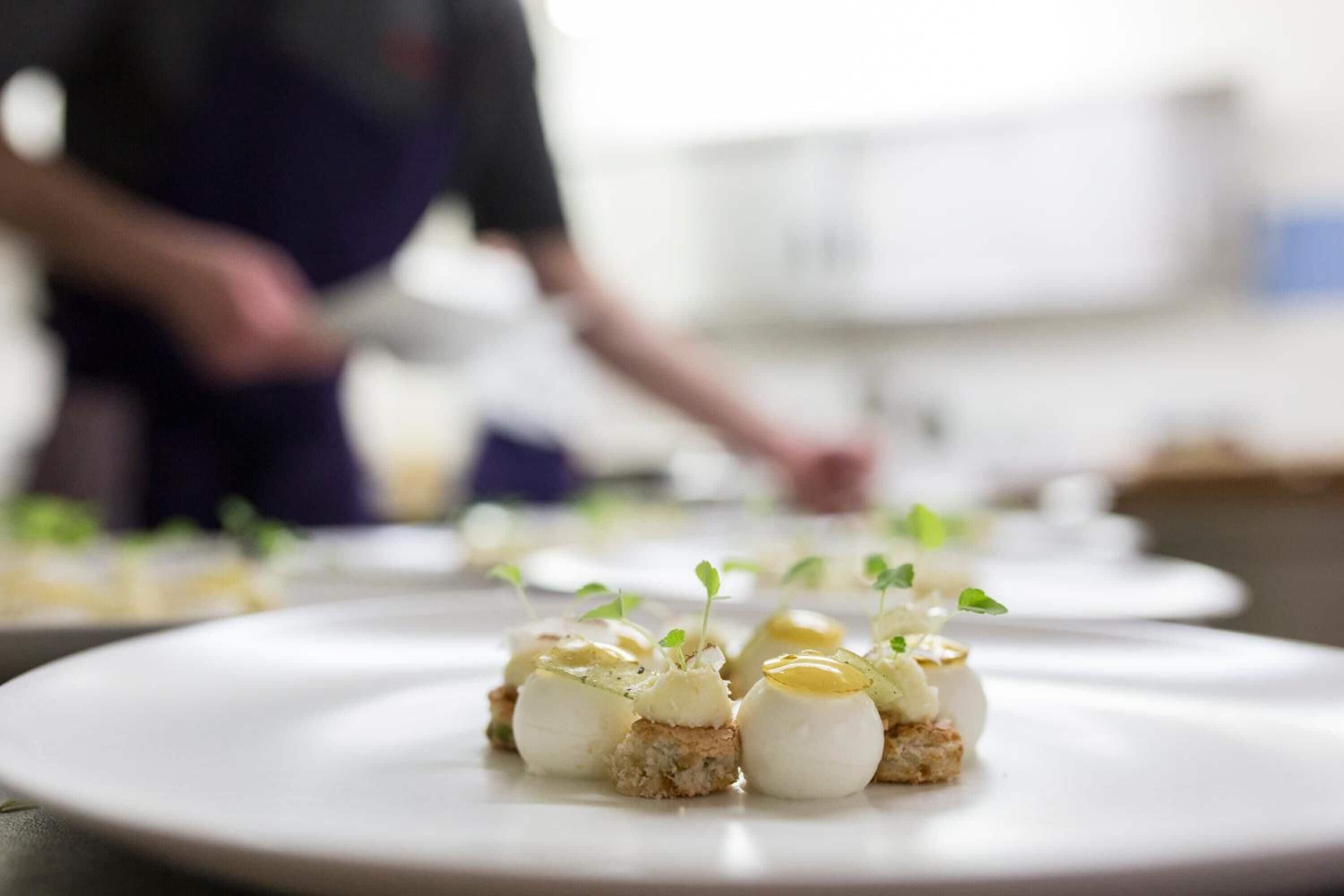 A close-up of a dish with a creamy topping and a garnish on a white plate.