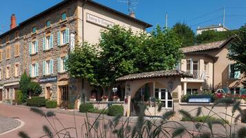 A hotel with a stone facade, multiple windows, and a sign indicating it is a hotel.