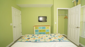 Una camera da letto con un letto, una cassettiera, una televisione e un armadio.