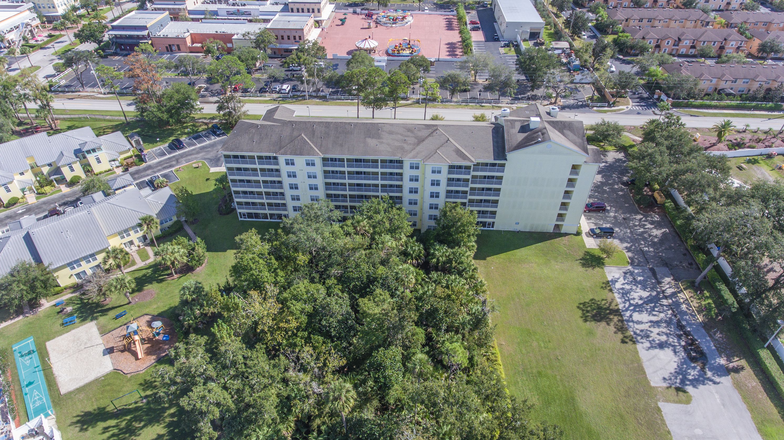 A multi-story hotel with a central courtyard and surrounding greenery.