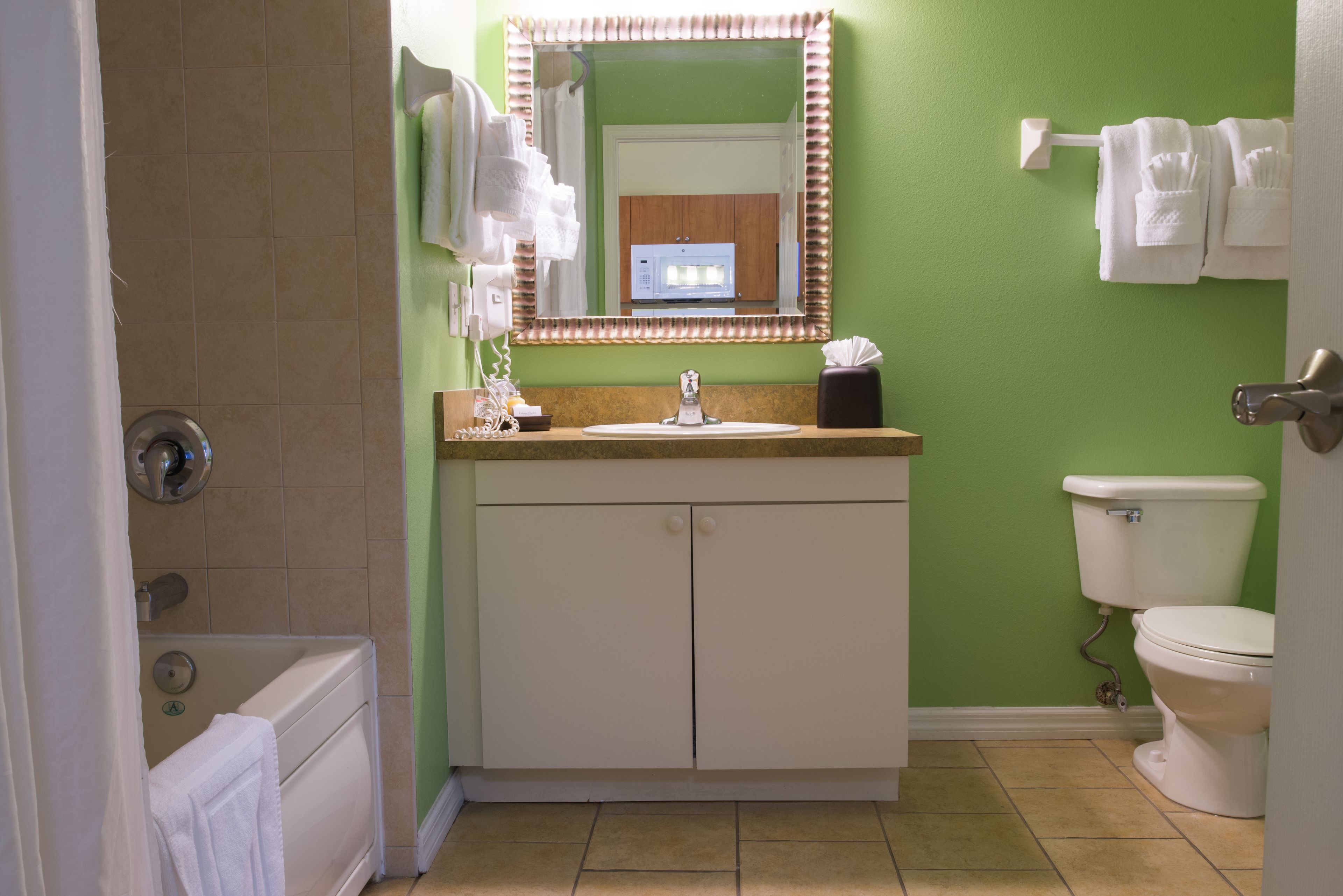 A bathroom with a sink, mirror, toilet, and bathtub.