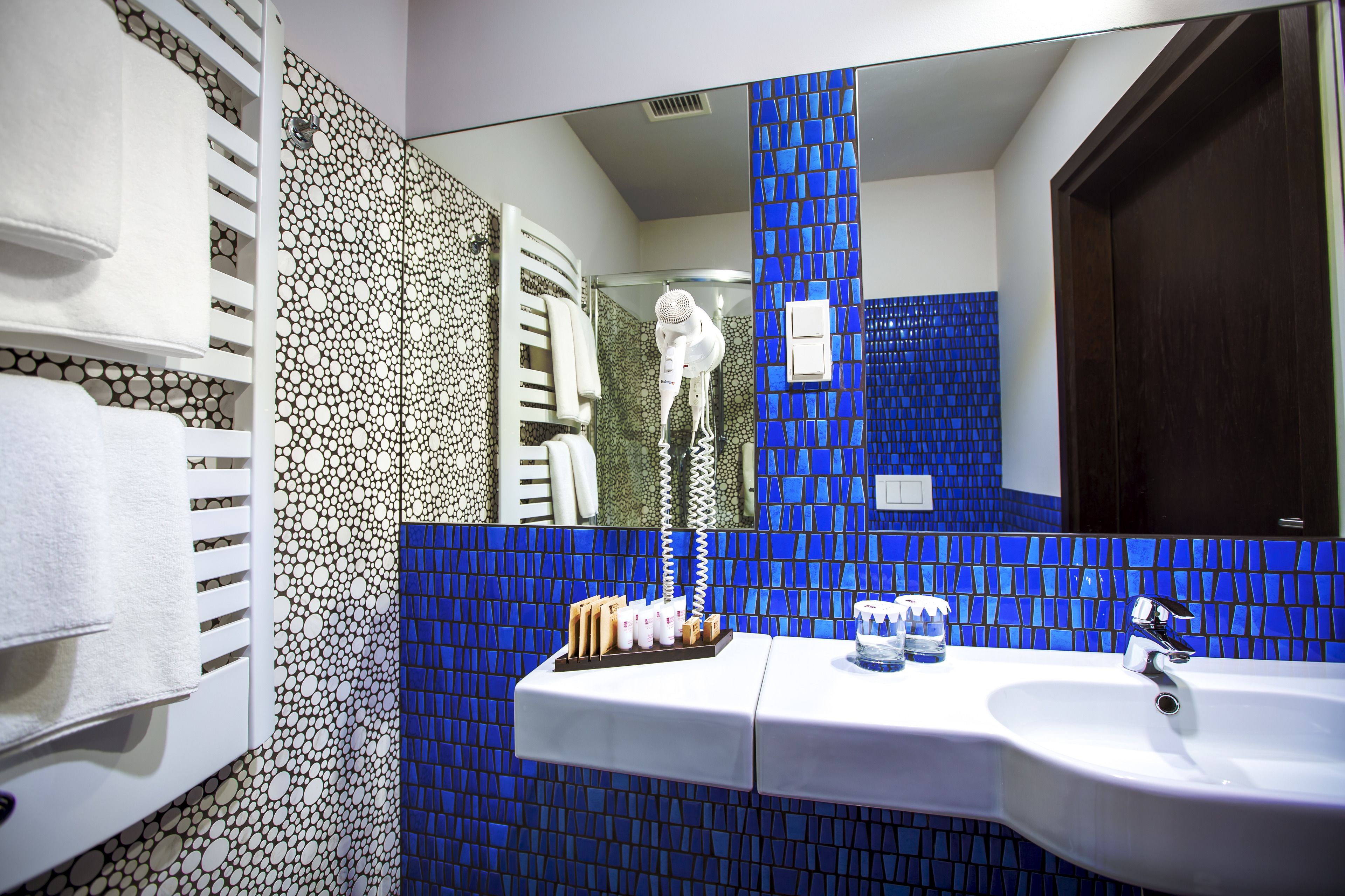 A bathroom with a sink, mirror, and towel rack.