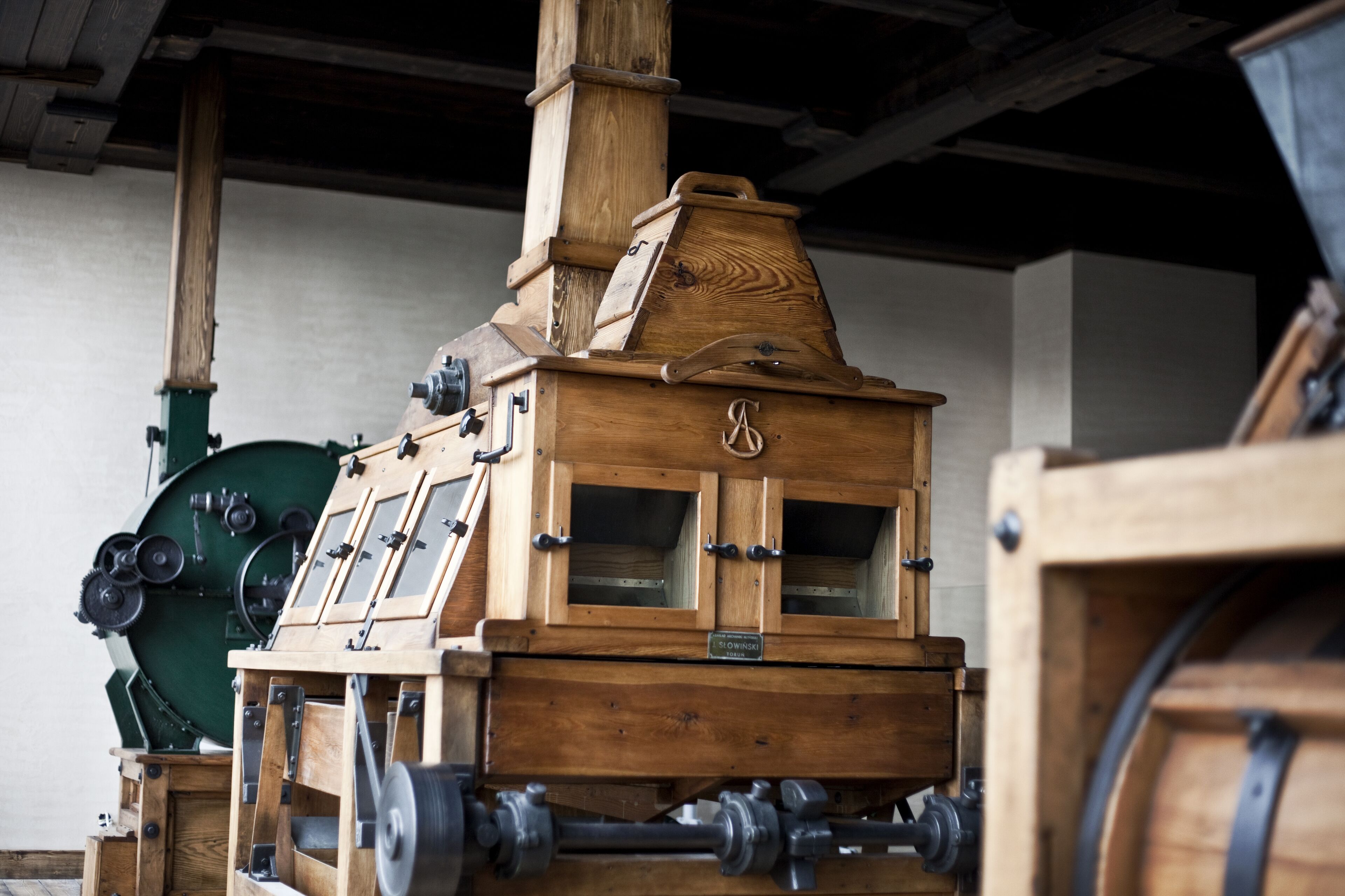 A wooden mechanical device with multiple windows and a chimney, likely used for industrial purposes.
