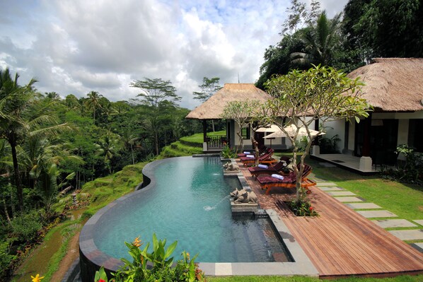 Outdoor pool, an infinity pool, pool umbrellas, pool loungers