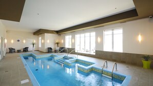 An indoor swimming pool with clear water, steps leading into it, and a tiled floor. - Imperia Hotel & Suites Terrebonne (Terrebonne)