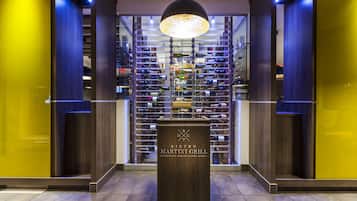 Una cantina vinicola con un podio di legno al centro, con l'indicazione "BISTRO MARTINI GRILL".
