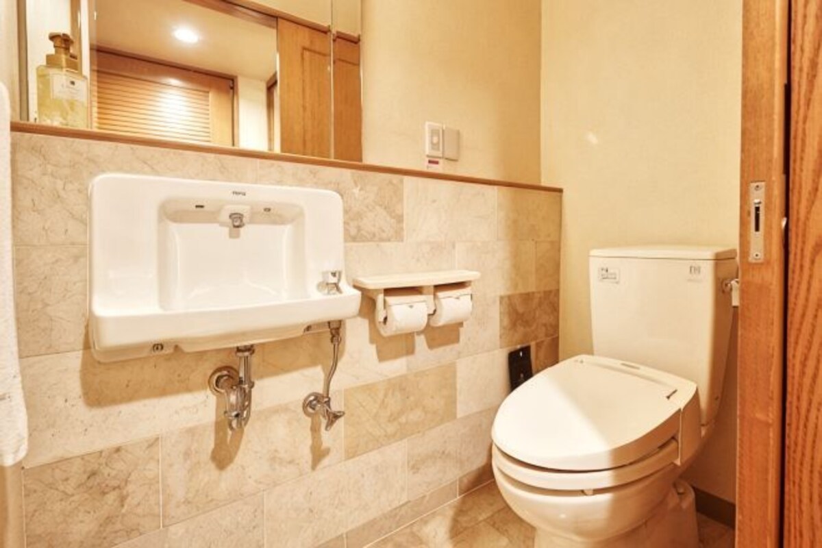 Un baño con lavabo, inodoro y espejo.