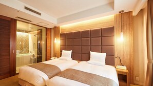 A hotel room with a large bed, a separate bathroom, and a wooden headboard. - Pacific Hotel Okinawa (Naha)