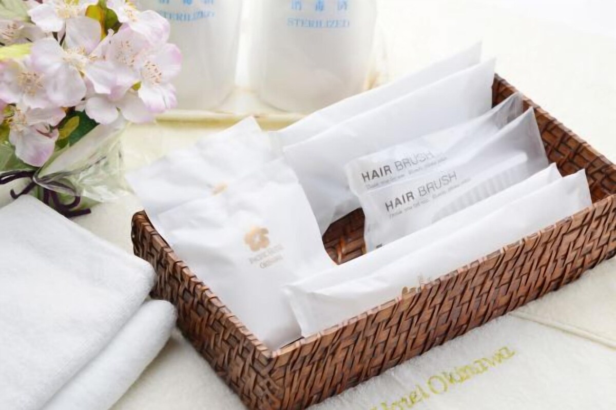 Una cesta de mimbre con cepillos para el cabello y una toalla blanca.