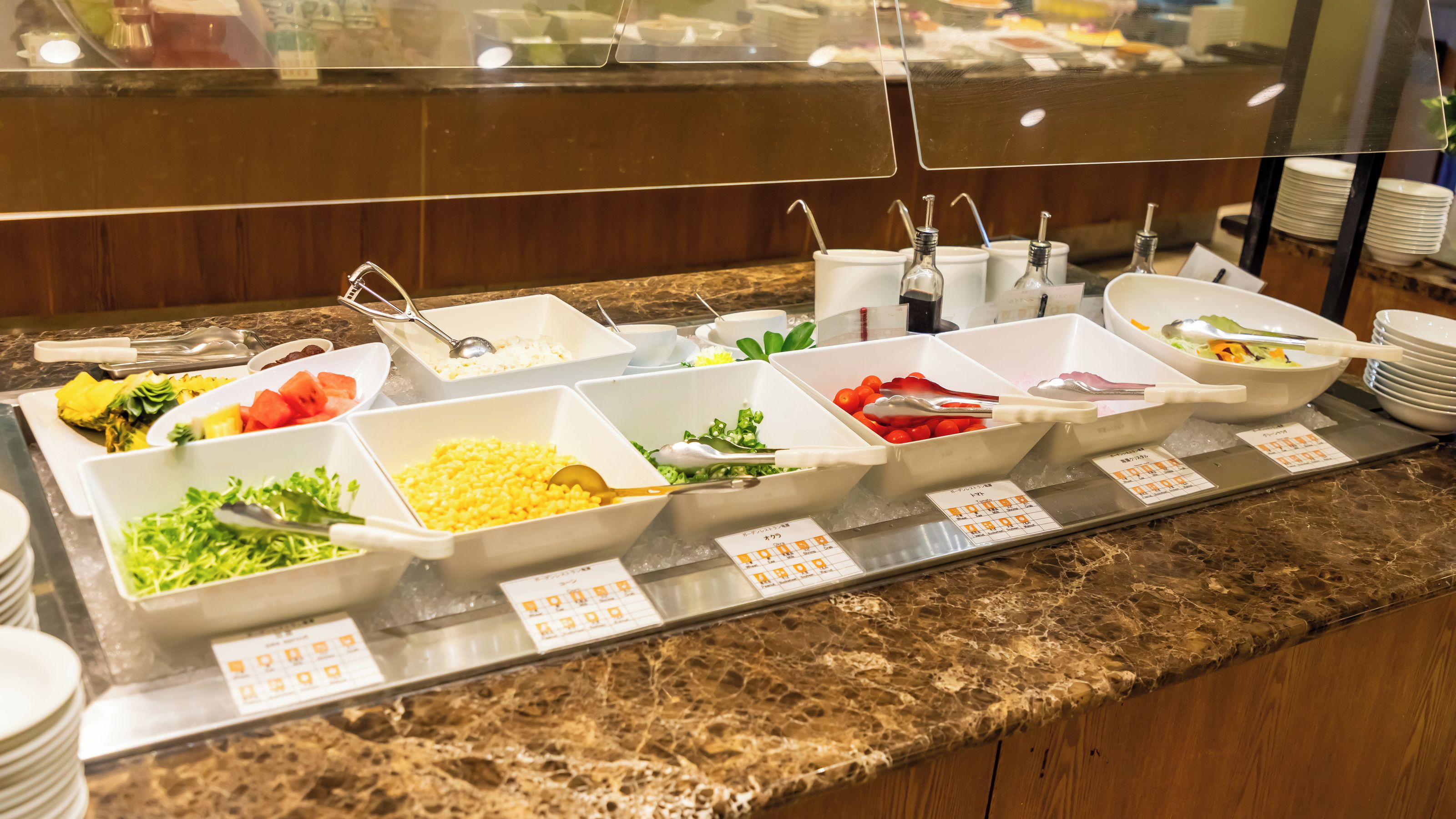 A buffet with various food items and utensils.