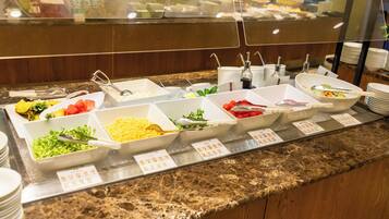 A buffet with various food items and utensils.