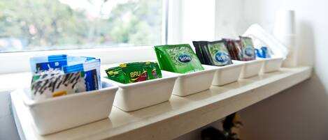 Een plank met diverse verpakte items, waarschijnlijk snacks of toiletartikelen, gerangschikt in witte bakken.
