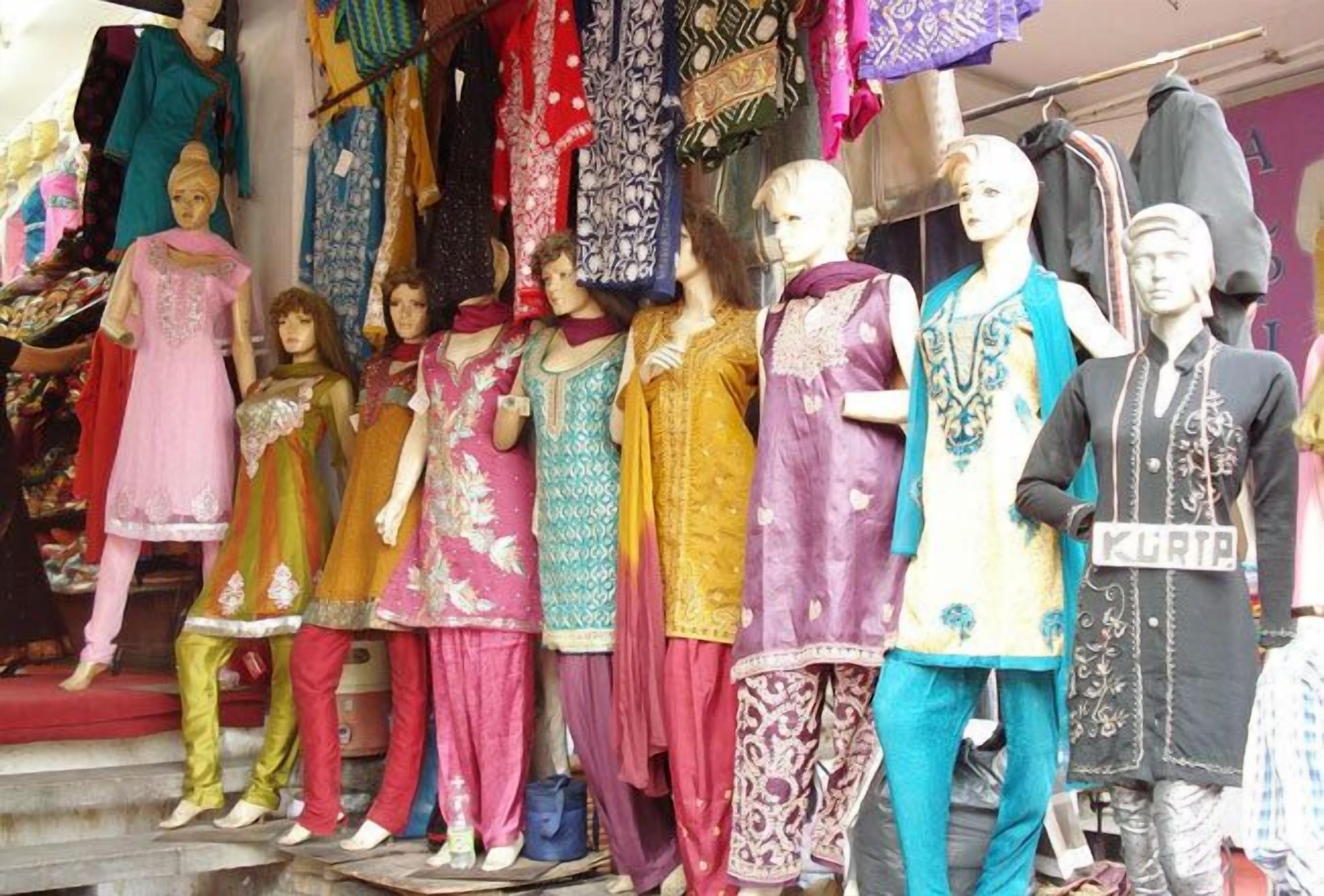 Mannequins dressed in colorful traditional attire displayed in a shop.