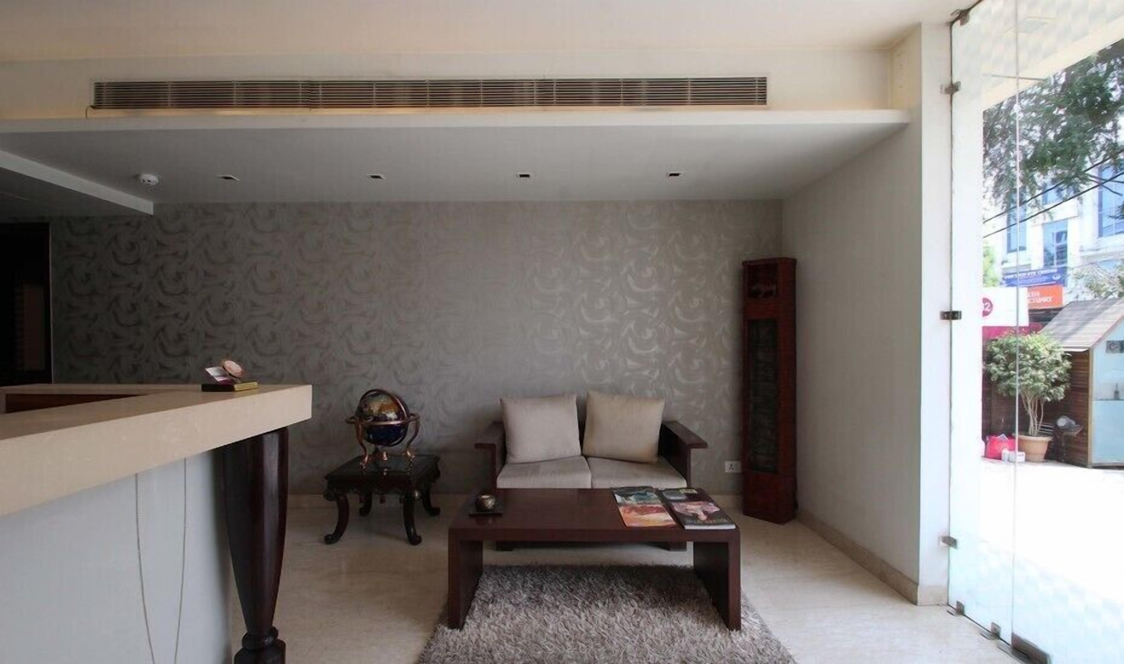 A compact living space with a sofa, a coffee table, a small side table, and a globe on a stand.