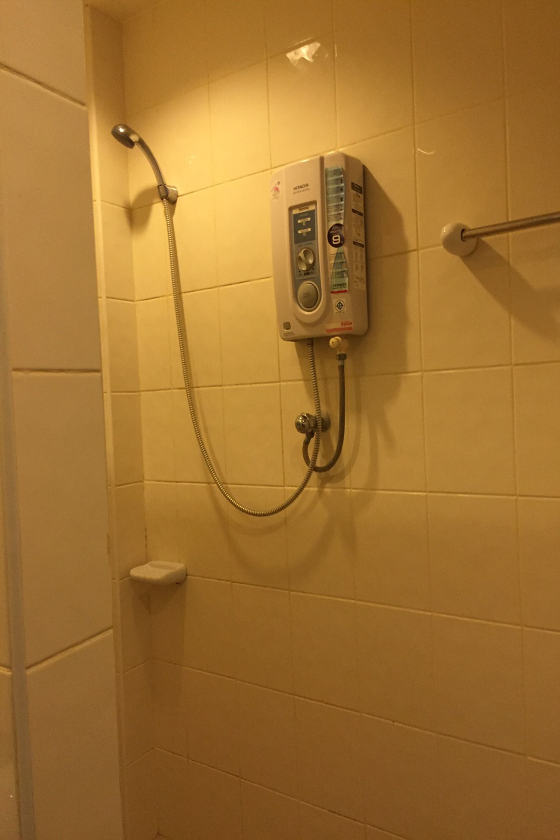 Een douche met een handdouche en een bedieningspaneel.