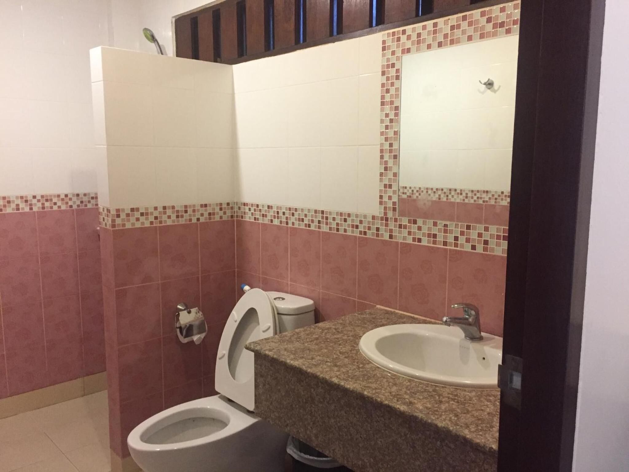 Un baño con dos inodoros, un lavabo y un espejo.