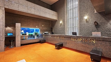 A reception area with a granite counter, a large window, and a carpeted floor.