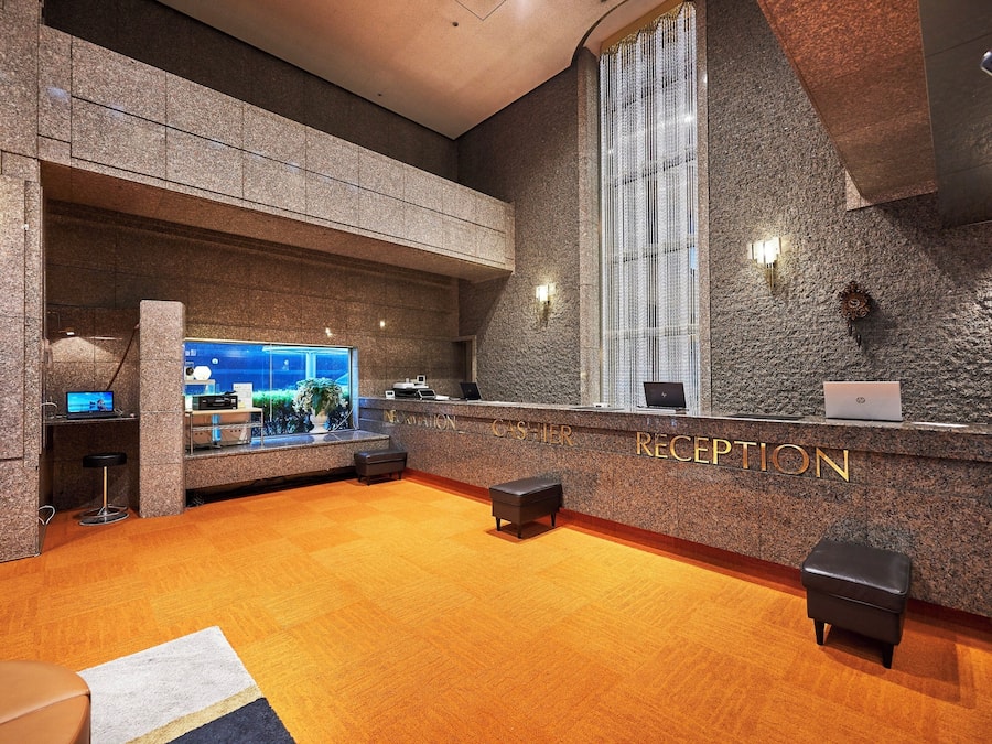 A reception area with a granite counter, a large window, and a carpeted floor.