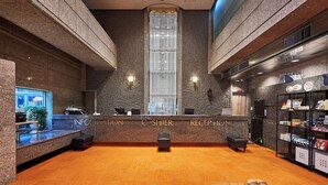 A reception area with a stone wall, a large window, and a reception desk labeled "Information, Cashier, Reception". - Kobe Sannomiya Union Hotel (Kobe)