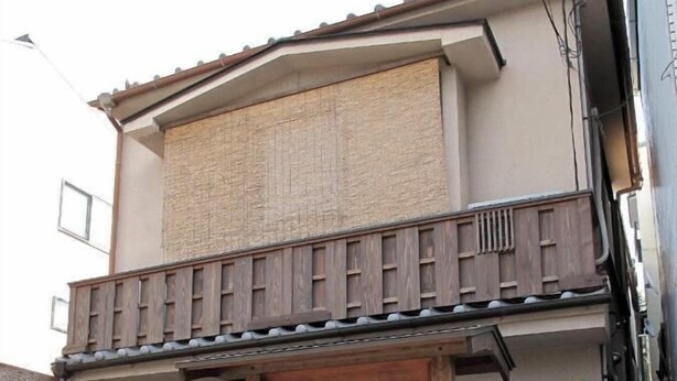 A traditional Japanese building with a wooden gate, a signboard, and a tiled roof. - Guest House Higashiyama (Kyoto)