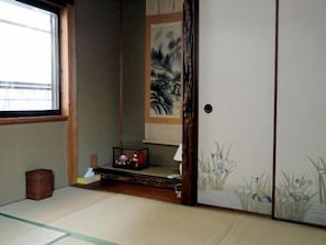 A traditional Japanese room with tatami flooring, a shoji screen, and a sliding door.