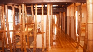 A room with a wooden floor, bamboo columns, and a wooden bench. - Takaragawa Onsen Osenkaku (Minakami)
