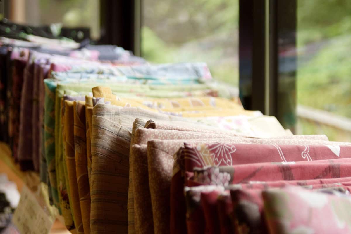 Exhibición de telas dobladas en varios colores y diseños, presumiblemente a la venta.