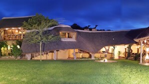 A modern house with unique architecture, including conical roofs and a well-maintained lawn. - Lalibela Game Reserve (Grahamstown)