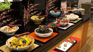 A buffet table with various dishes and bowls.