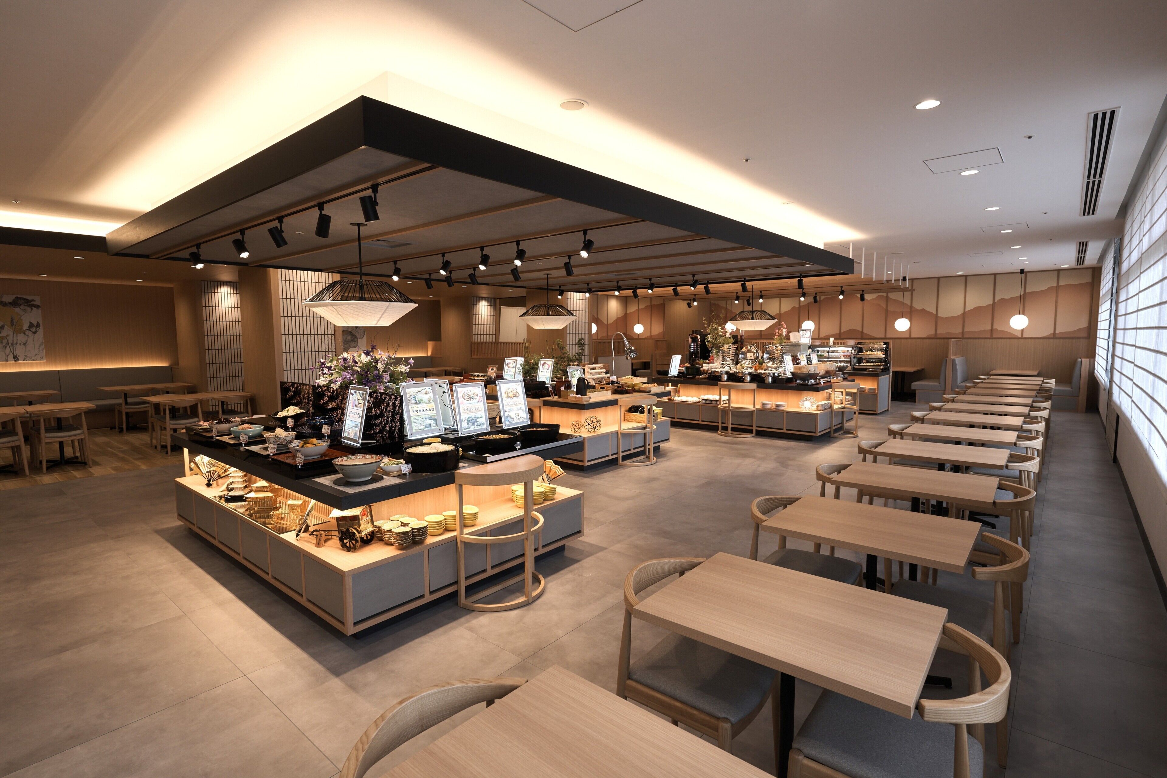 Um restaurante moderno com várias áreas de refeição, mobiliário de madeira e diversos displays de comida.