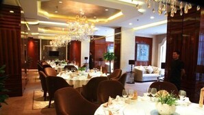 Un comedor con mesas redondas, sillas de cuero marrón y un candelabro.