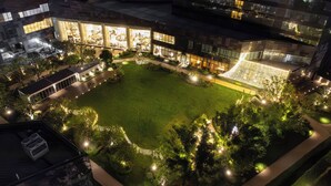 A modern building with a central courtyard, surrounded by greenery and illuminated by ambient lighting. - Pan Pacific Ningbo (Ningbo)