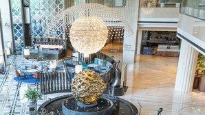 A spacious lobby with a central fountain, seating areas, and a bar. - Pan Pacific Ningbo (Ningbo)