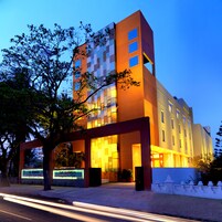 Un hotel moderno con una entrada destacada, ventanas amplias y una fachada bien iluminada.