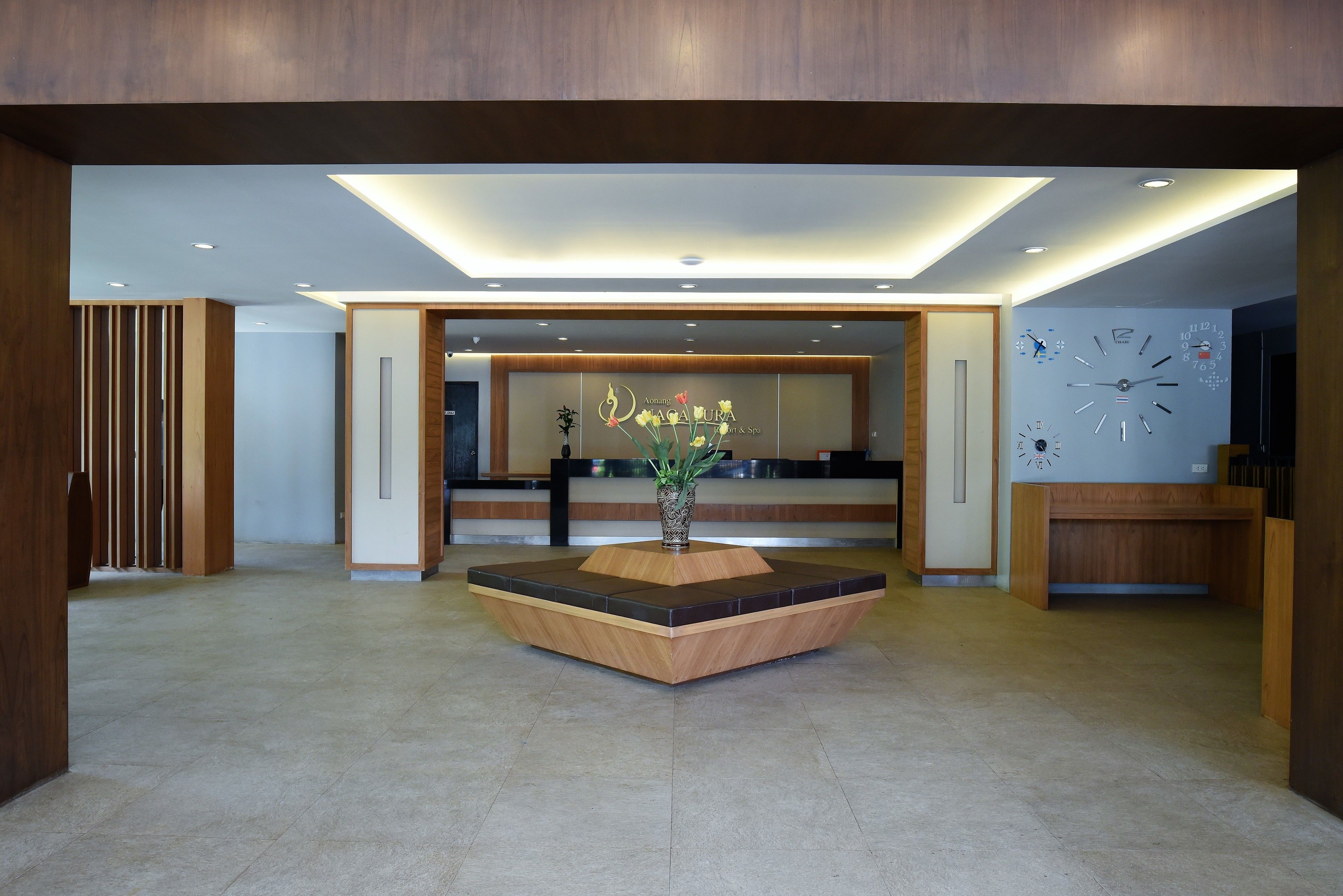 Et moderne receptionsområde med en central træbænk, en reception og et vægur.