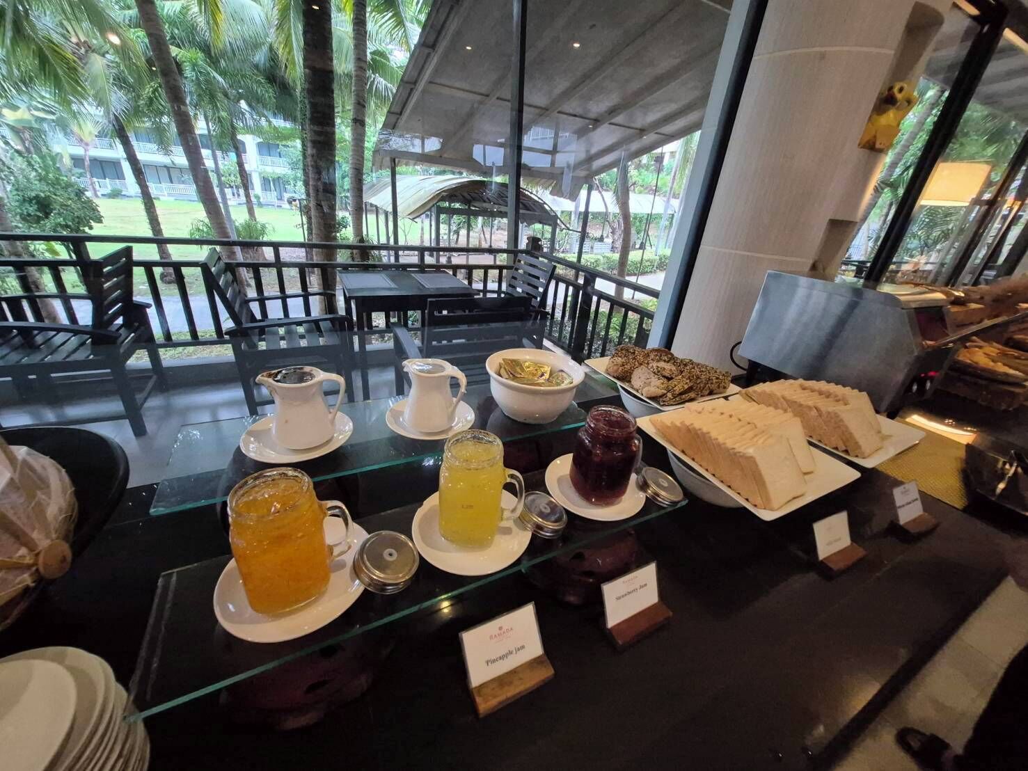 Un bufé de desayuno con diferentes alimentos y bebidas, incluyendo panqueques, pasteles y ponche de frutas.