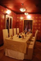 Comedor con una mesa larga dispuesta para seis personas, rodeada de sillas blancas.
