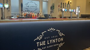 A bar area with a counter displaying various bottles and a sign reading "The Lynton Eat Sleep Drink." - Lynton House (Teignmouth)