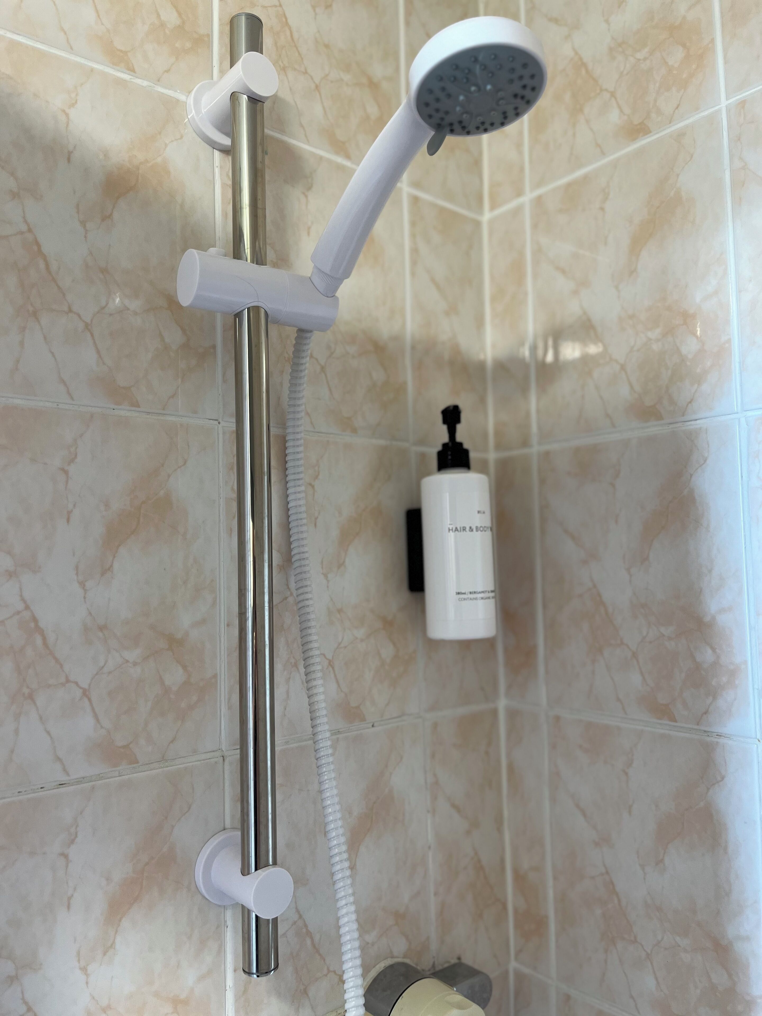 A shower with a handheld showerhead and a flexible hose.