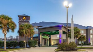 A La Quinta hotel with a modern entrance, palm trees, and a well-lit facade. - La Quinta Inn & Suites by Wyndham Boutte (Boutte)