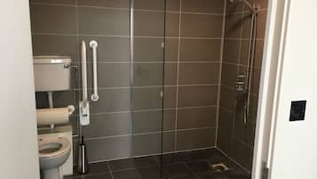 A modern bathroom with a shower, toilet, and bidet.