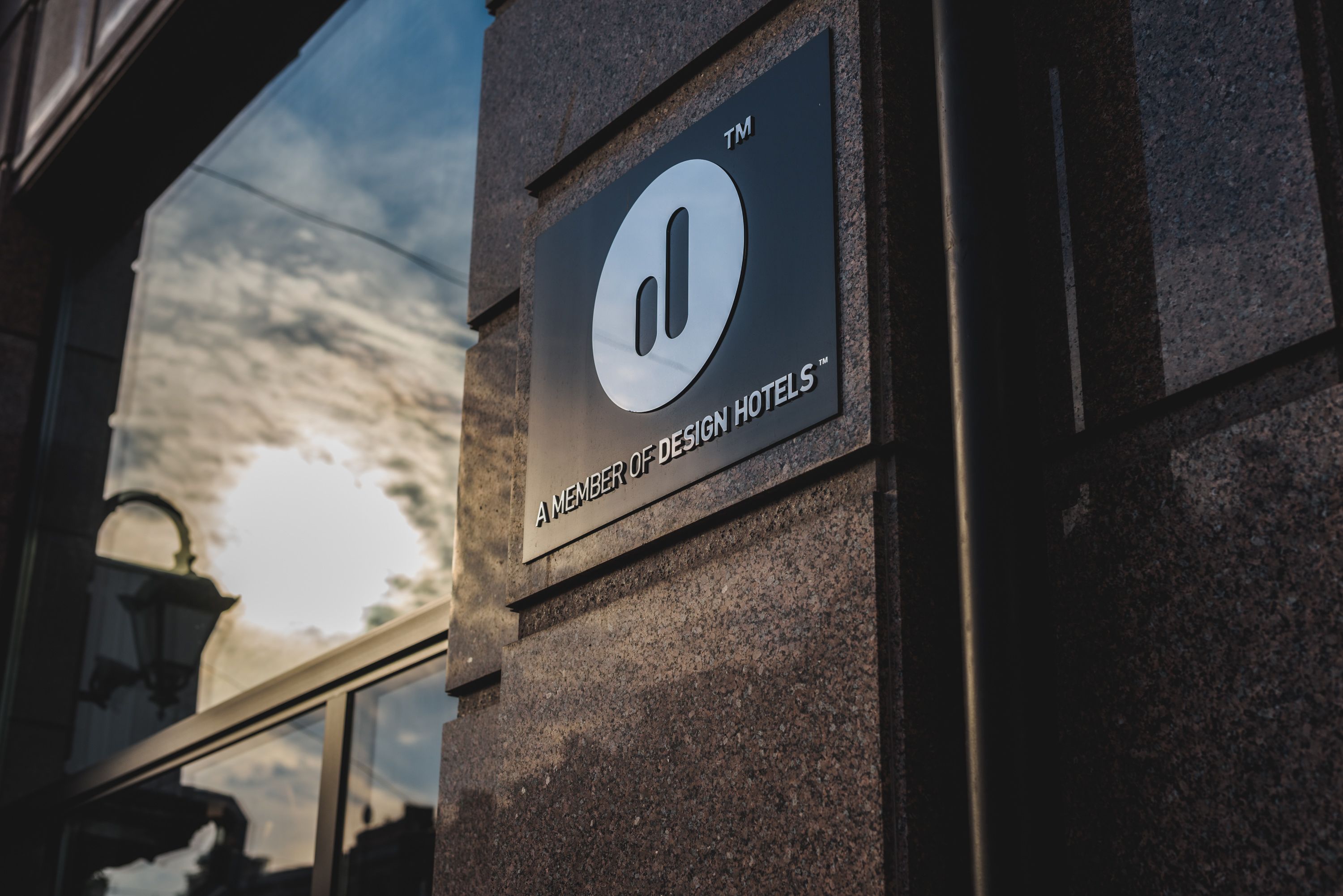 A sign for Design Hotels on a building facade.