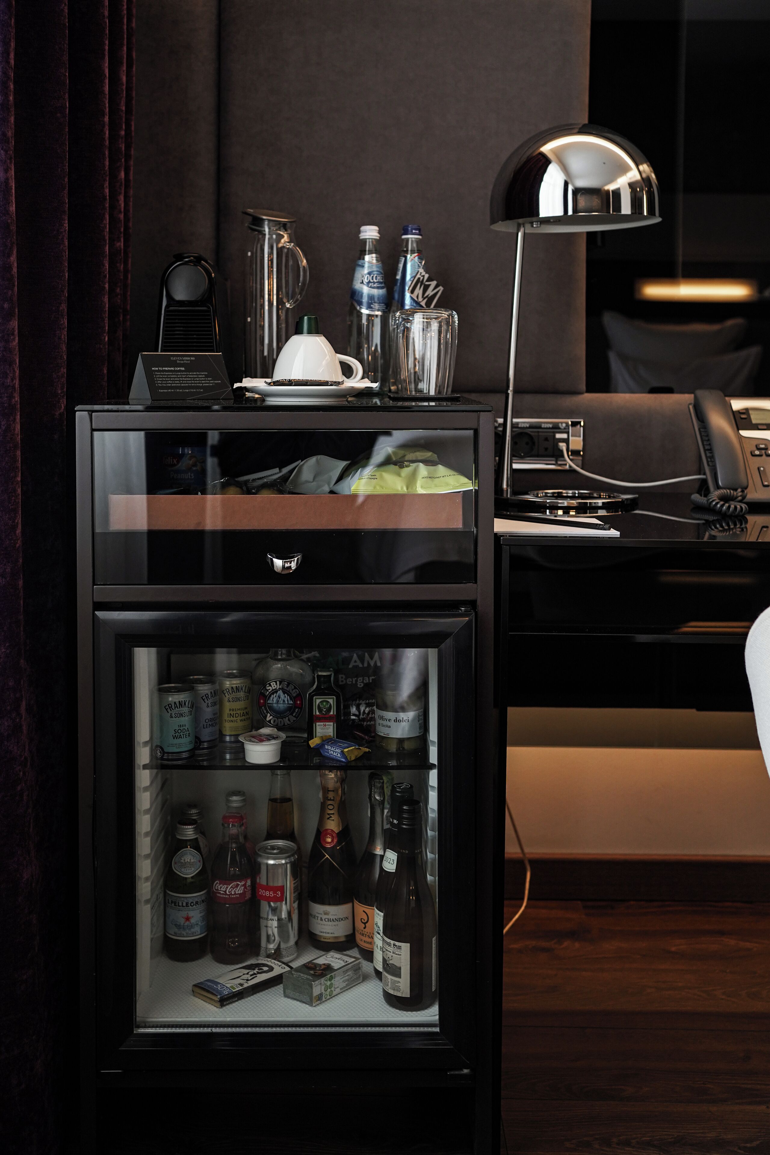 A minibar with a variety of beverages and a coffee maker.