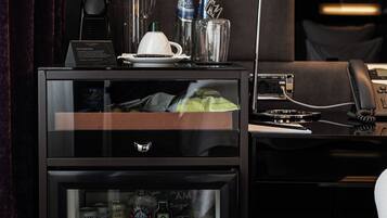A minibar with a variety of beverages and a coffee maker.