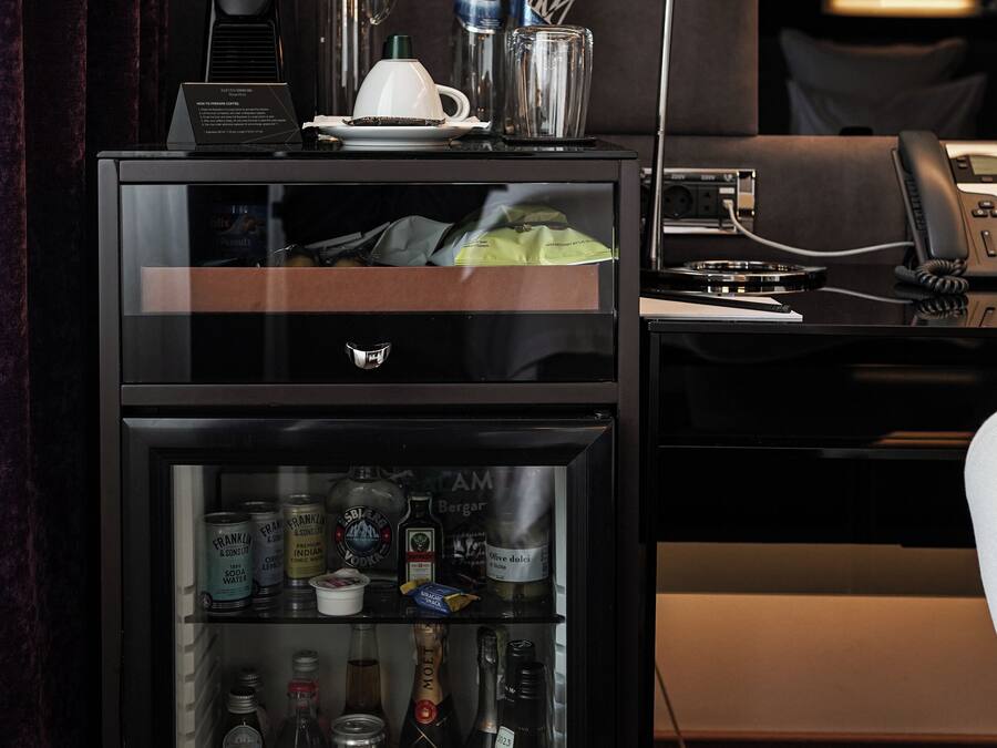 A minibar with a variety of beverages and a coffee maker.